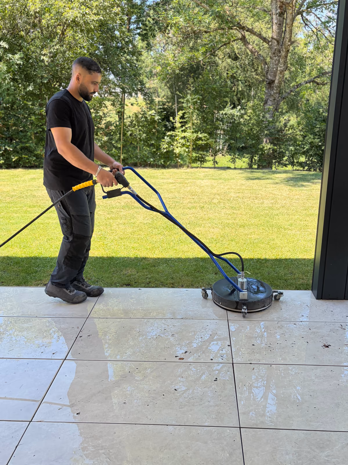 Blitzeblank Mitarbeiter reinigt Terrassenplatten mit einem Flächenreiniger