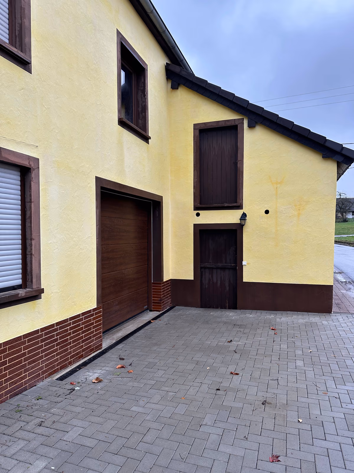 Saubere gelbe Einfamilienhaus-Fassade nach der Fassadenreinigung