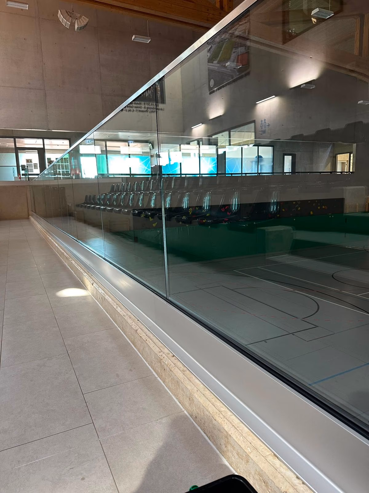Streifenfrei gereinigtes Glasgeländer und Glaswände in einer Sporthalle
