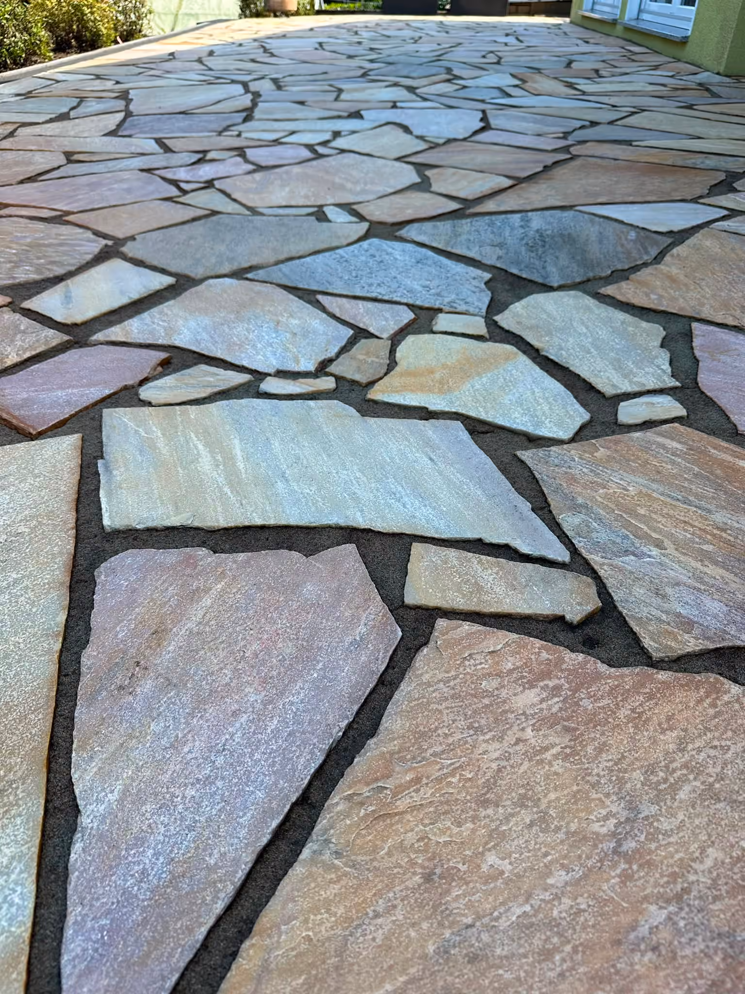 Gereinigte Naturstein-Terrasse mit Polygonalplatten als Ergebnis der Steinreinigung